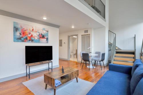 a living room with a blue couch and a tv at Bright and Modern Loft in Louisville # 208 in Louisville