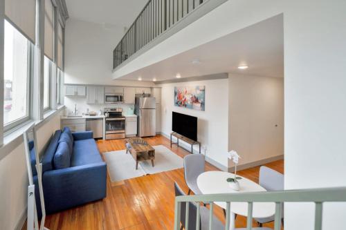 a living room with a blue couch and a kitchen at Bright and Modern Loft in Louisville # 208 in Louisville