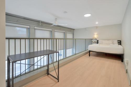 a bedroom with a bed and a desk in a room at Bright and Modern Loft in Louisville # 208 in Louisville