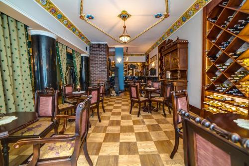 a restaurant with tables and chairs and wine racks at Małopolanka & Spa in Krynica Zdrój