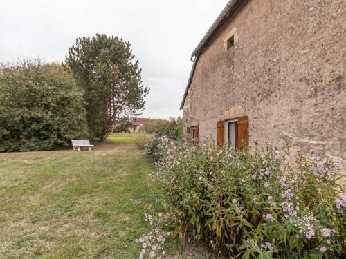 a stone building with a bench next to it at Chambres Confortables avec Petit Déjeuner Inclus et Salon de Jardin - FR-1-583-284 in Melin