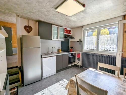 Il comprend une cuisine équipée d'un réfrigérateur et d'une table. dans l'établissement Appartement cosy à La Bresse avec terrasse et parking, animaux admis - FR-1-589-689, à La Bresse