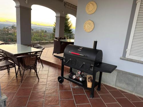 a grill in a living room with a table and a dining room at Splendid Villa Magna with Pool and Park - Langhe Hills in Govone