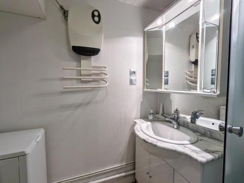 une salle de bain blanche avec un lavabo et un miroir dans l'établissement Appartement cosy à La Bresse avec terrasse et parking, animaux admis - FR-1-589-689, à La Bresse