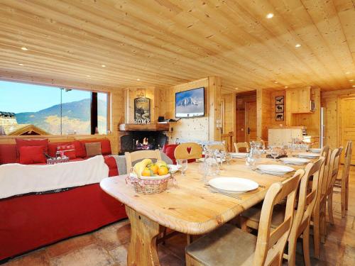 une salle à manger avec une grande table et des chaises en bois dans l'établissement Chalet de luxe 8 chambres avec sauna et parking à Courchevel La Tania - FR-1-575-232, à Courchevel