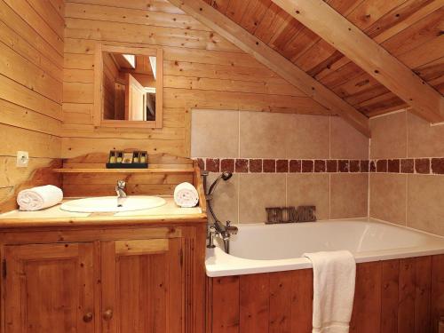 une salle de bain avec une baignoire et un lavabo dans l'établissement Chalet de luxe 8 chambres avec sauna et parking à Courchevel La Tania - FR-1-575-232, à Courchevel