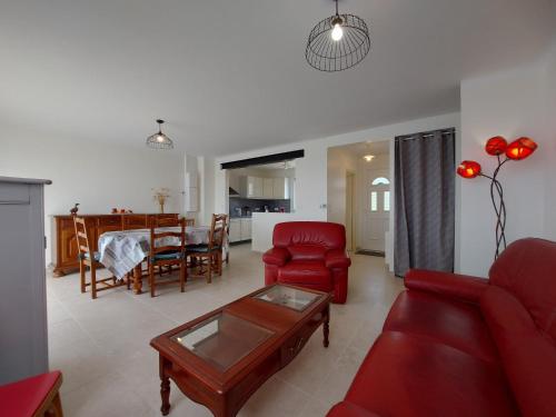 un salon avec un canapé rouge et une table dans l'établissement Maison familiale au calme avec jardin et barbecue - FR-1-581-144, à Saumeray