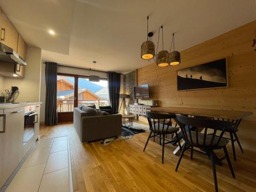 une cuisine et un salon avec une table et des chaises dans l'établissement Appartement lumineux avec balcons, WIFI et parking à Samoëns - FR-1-624-172, à Samoëns