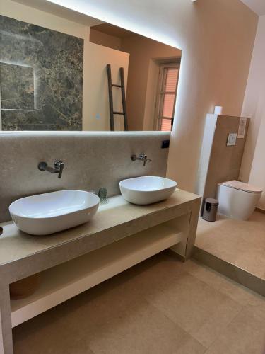 a bathroom with two sinks on a counter with a mirror at Splendid Villa Magna with Pool and Park - Langhe Hills in Govone
