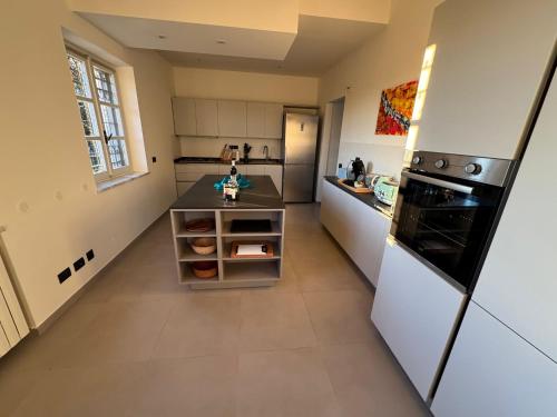 a kitchen with a counter and a refrigerator at Splendid Villa Magna with Pool and Park - Langhe Hills in Govone