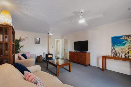 a living room with a couch and a tv at Retreat on Broadwater, pet friendly in Busselton