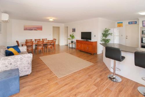 a living room with a couch and a kitchen and a table at Retreat on Broadwater, pet friendly in Busselton