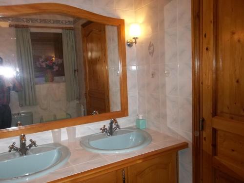 Baño con 2 lavabos y espejo en Au bon Accueil anciennement Le Jardin fleuri en Bonnac