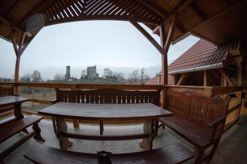 a wooden table and benches in a pavilion at Vár-Liget Vendégház in Kisnána