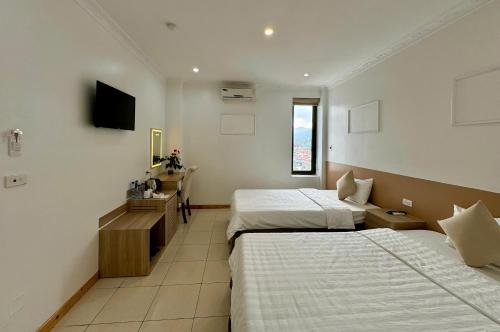 a hotel room with two beds and a television at Cong Fu Hotel in Bắc Hà