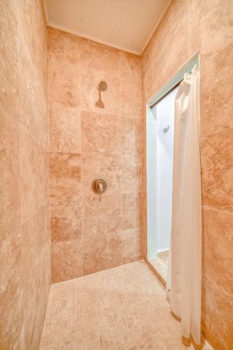 a bathroom with a shower with a glass door at Caribe Tesoro in West Bay
