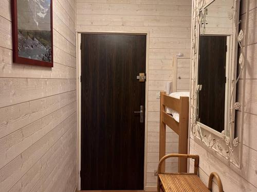 une porte en bois dans une pièce avec un banc en bois dans l'établissement Grand Studio Centre Ville 4-6 Pers, Parking Proche - FR-1-234-332, à Cauterets