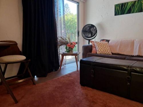a living room with a couch and a window at Sweet Guesthouse in Waitara