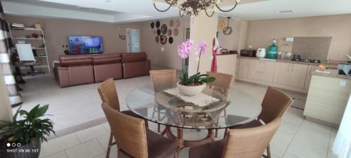 a dining room with a glass table and chairs at A melhor acomodação entre Pinhais e Curitiba - quarto para até O4 pessoas em casa com garagem in Curitiba