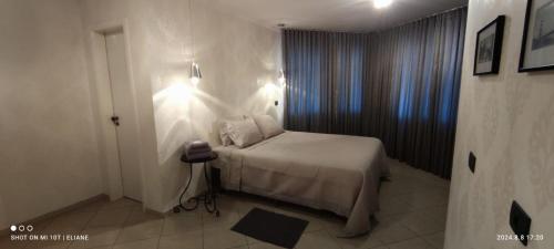 a small bedroom with a bed and a window at A melhor acomodação entre Pinhais e Curitiba - quarto para até O4 pessoas em casa com garagem in Curitiba