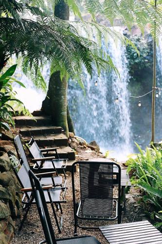a table and chairs in front of a waterfall at Zenda Glamping in Bao Loc