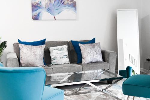 a living room with a couch and a glass coffee table at Serene Condo W/ LED Lights In Heart Of Raleigh in Raleigh
