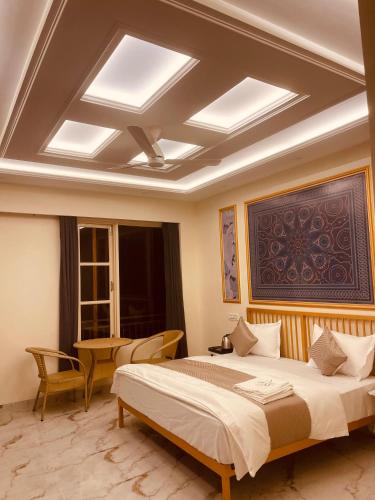 a bedroom with a large bed with a coffered ceiling at Paradise Woodland Resort Chintpurni in Bharwain