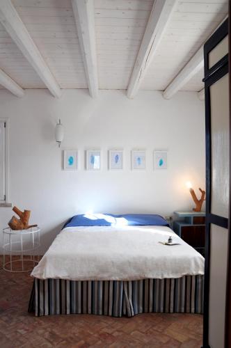 a bedroom with a large bed in a white room at I Trulli Sul Mare in Trani