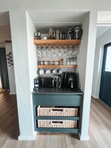 a kitchen with a blue cabinet with glasses on it at Witsand Whalecliff accommodation in Witsand
