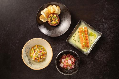 a table with three plates of food with carrots and dips at Dubai Marriott Harbour Hotel And Suites in Dubai