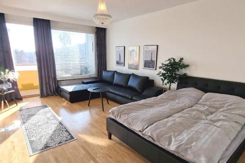Un dormitorio con una cama grande y un sofá. en Villa Ruths Stay Torni, en Kouvola