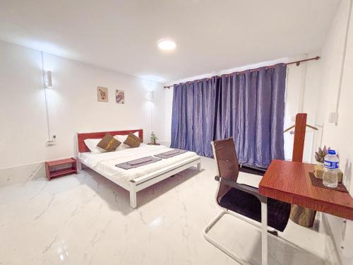 a bedroom with a bed and a table and a desk at CORAL in Koh Rong Sanloem