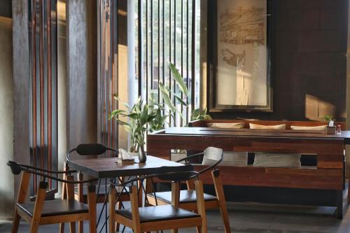 a table and chairs in front of a piano at Amphawa Nanon Hotel in Amphawa
