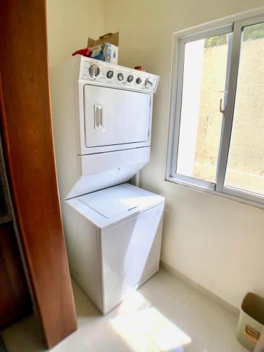 a white stove in a kitchen with a window at paradise close to the beach pool free parking,wifi- punta cana in Punta Cana