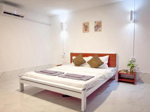 a bed in a white room with a white wall at CORAL in Koh Rong Sanloem