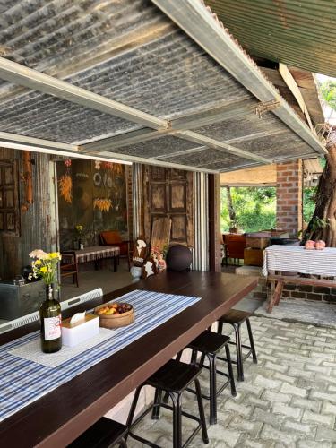 a dining room with a large wooden table and chairs at Lap nai doi homestay and space in Ban Thoet Thai