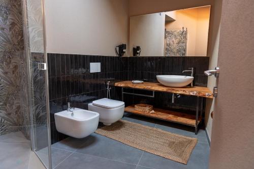 a bathroom with a toilet and a bidet and a sink at Le Relais du Bourg Chambres de charme Wellnes in Donnas
