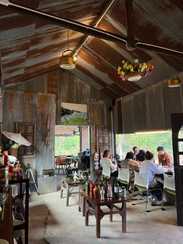 a group of people sitting at tables in a room at Lap nai doi homestay and space in Ban Thoet Thai