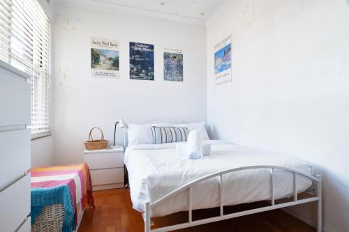 a white bedroom with a bed and a window at Beach Side Getaway - Brighton Le-Sands 2 Bedroom Apartment in Sydney