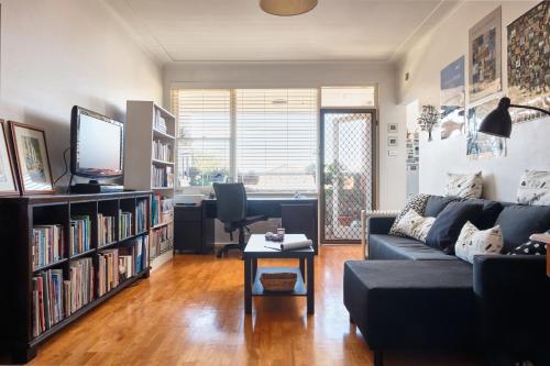 a living room with a couch and a tv at Beach Side Getaway - Brighton Le-Sands 2 Bedroom Apartment in Sydney