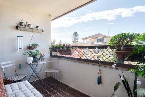 a balcony with potted plants and a couch at Beach Side Getaway - Brighton Le-Sands 2 Bedroom Apartment in Sydney