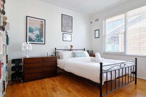 a bedroom with a large bed and a wooden floor at Beach Side Getaway - Brighton Le-Sands 2 Bedroom Apartment in Sydney