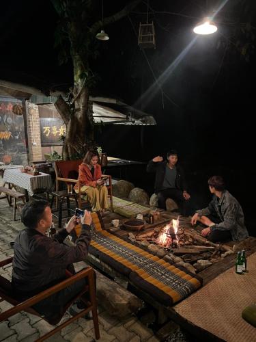 a group of people sitting around a fire at Lap nai doi homestay and space in Ban Thoet Thai
