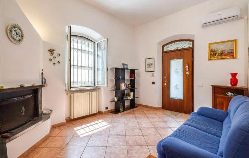 a living room with a blue couch and a fireplace at Stunning Home In Camogli With Kitchen in Camogli
