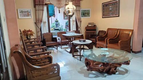 a living room with chairs and a glass table at D'Pari Homestay Magelang in Penggaron