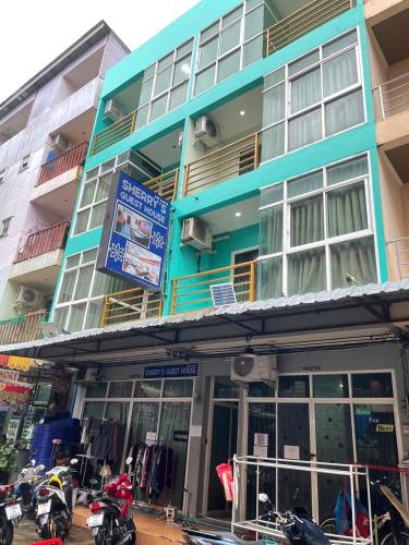 a blue building with motorcycles parked in front of it at SHERRY'S Guest House in Patong Beach
