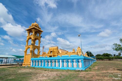 a yellow and blue building with a clock tower at Golden Beach Hotel & Restaurant in Trincomalee