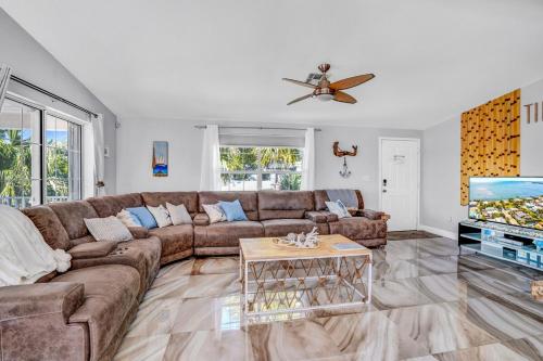 a living room with a couch and a tv at Tiki Time! Pool-tiki Hut-kayaks-grill-ocean View! in Marathon