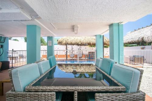 a porch with chairs and a table and a pool at Tiki Time! Pool-tiki Hut-kayaks-grill-ocean View! in Marathon