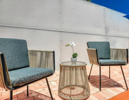 two chairs and a table with a vase on a patio at Tiki Time! Pool-tiki Hut-kayaks-grill-ocean View! in Marathon